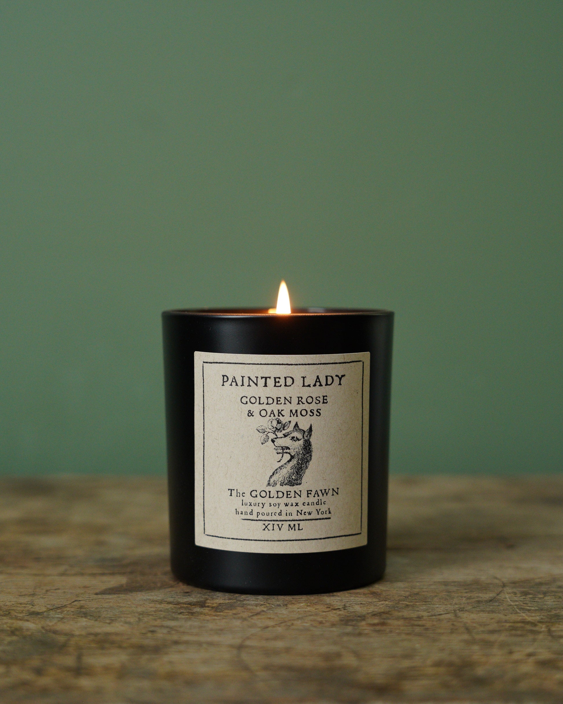 Candle with a label on a wooden surface and green background